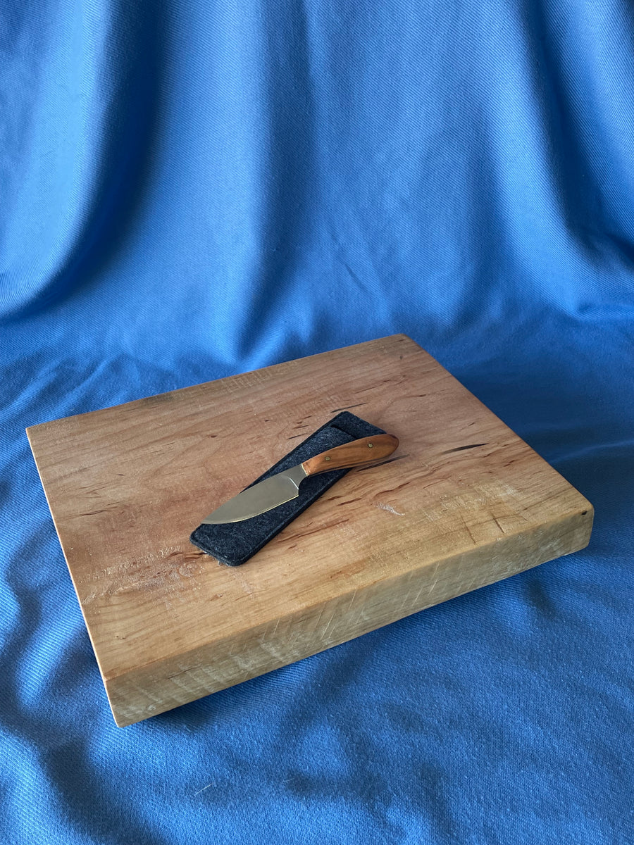 large chef knife sticks out from wooden cutting board om black shabby  wooden background. Red onion by Moon Soul. Photo stock - StudioNow